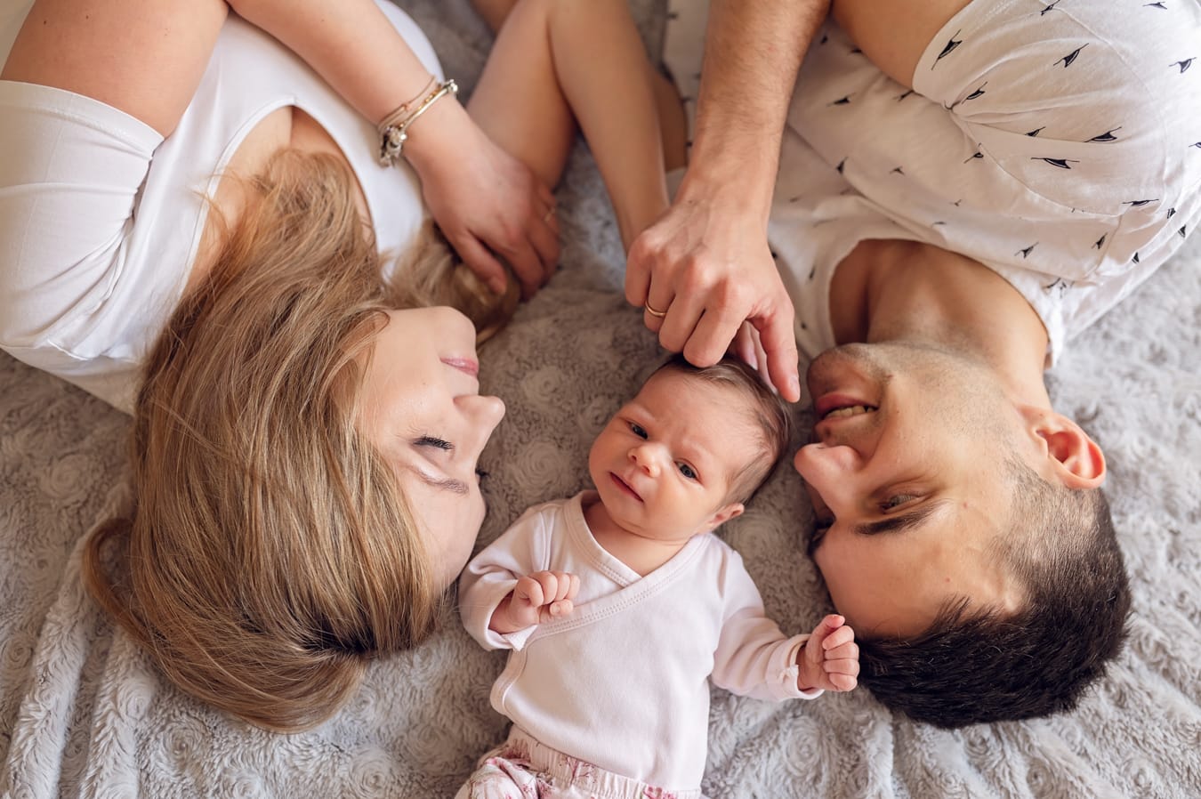 Portret rodziny z noworodkiem na łóżku sesja Gdańsk