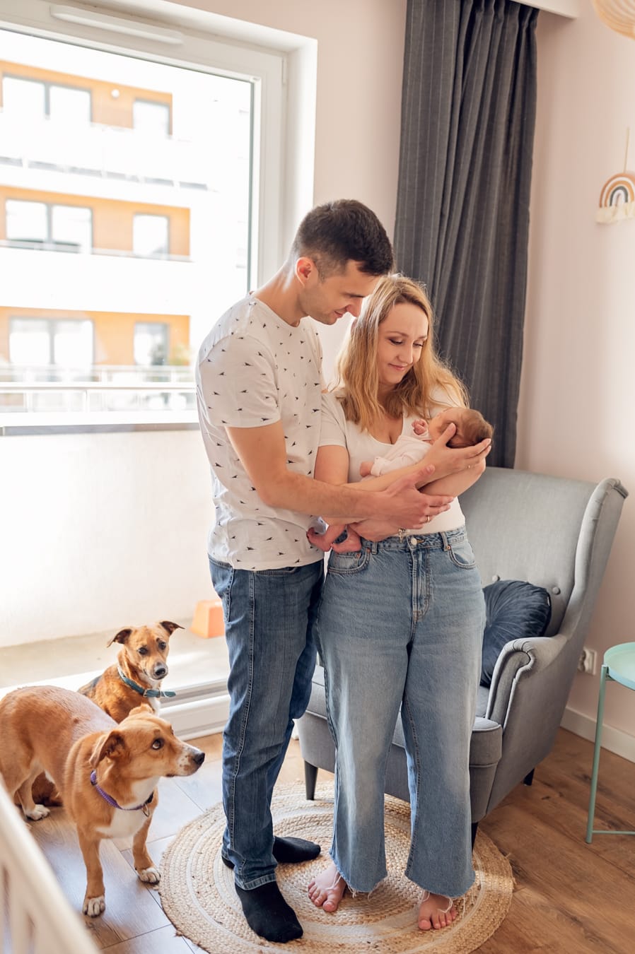 Rodzice tuląi noworodka a psy są obok sesja noworodkowa w domu Gdańsk
