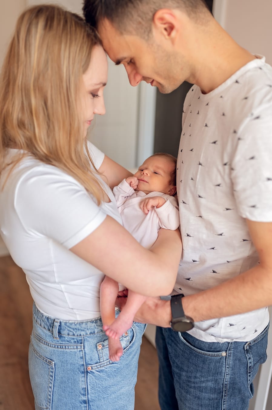 Rodzice tulą noworodka sesja noworodkowa w domu Gdańsk
