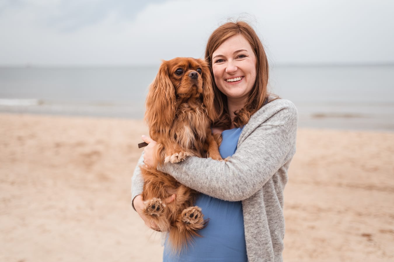 Mama w ciąży trzyma Cavaliera sesja ciążowa z psem