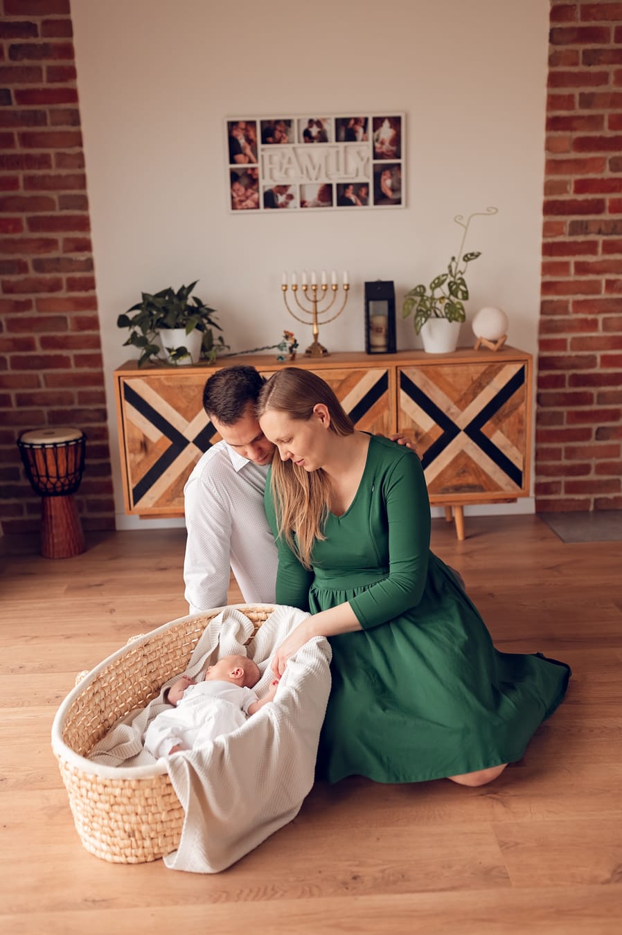 Rodzice patrzą na noworodka w koszu rodzinna sesja noworodkowa