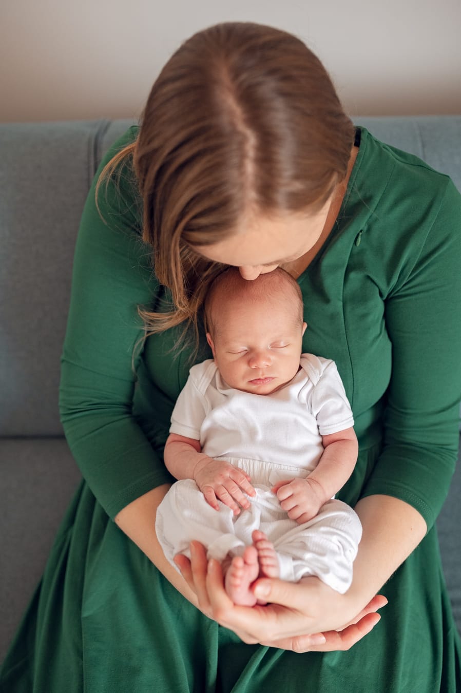 Mama całuje noworodka rodzinna sesja noworodkowa