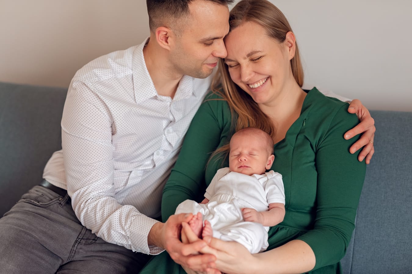 Roześmiani rodzice z noworodkiem sesja w domu Trójmiasto