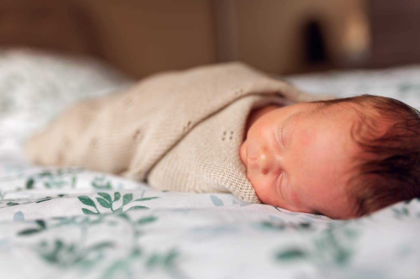 Śpiący noworodek otulony kocykiem sesja noworodkowa w domu Gdynia