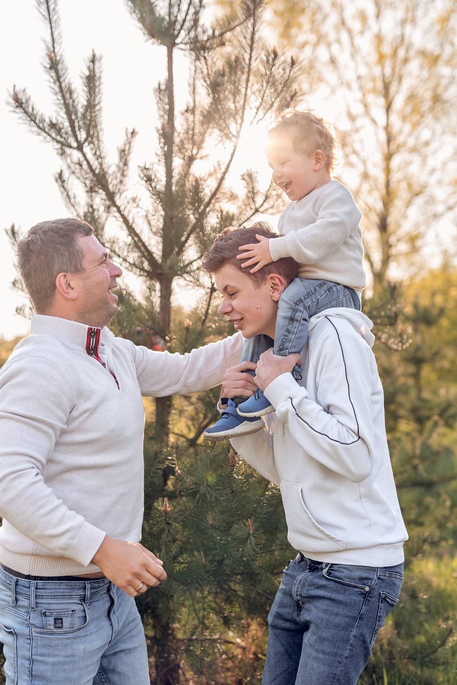 Starszy brat bierze młodszego na barana sesja rodzinna na łące