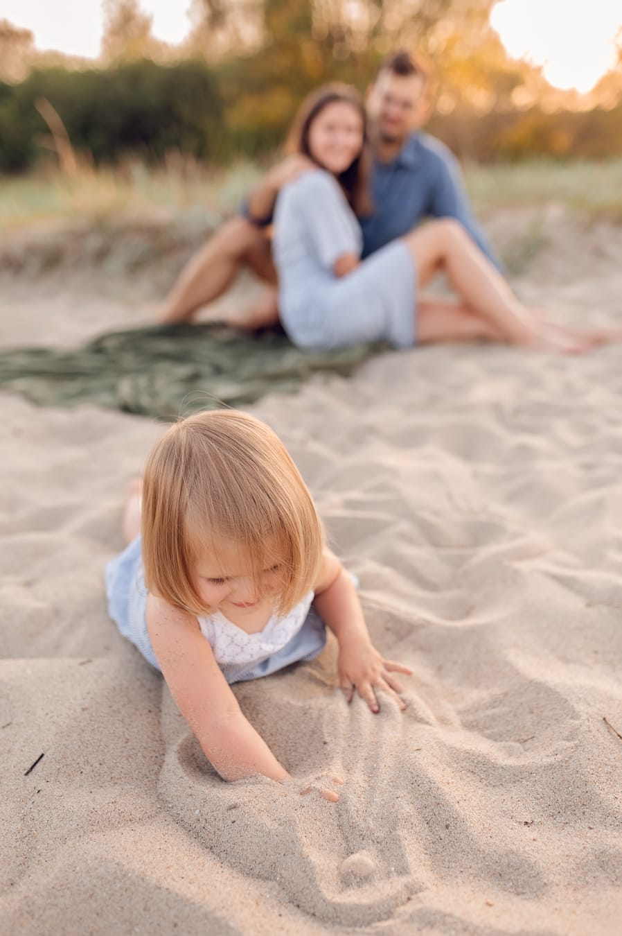 Dziewczynka kopie piasek sesja rodzinna nad morzem