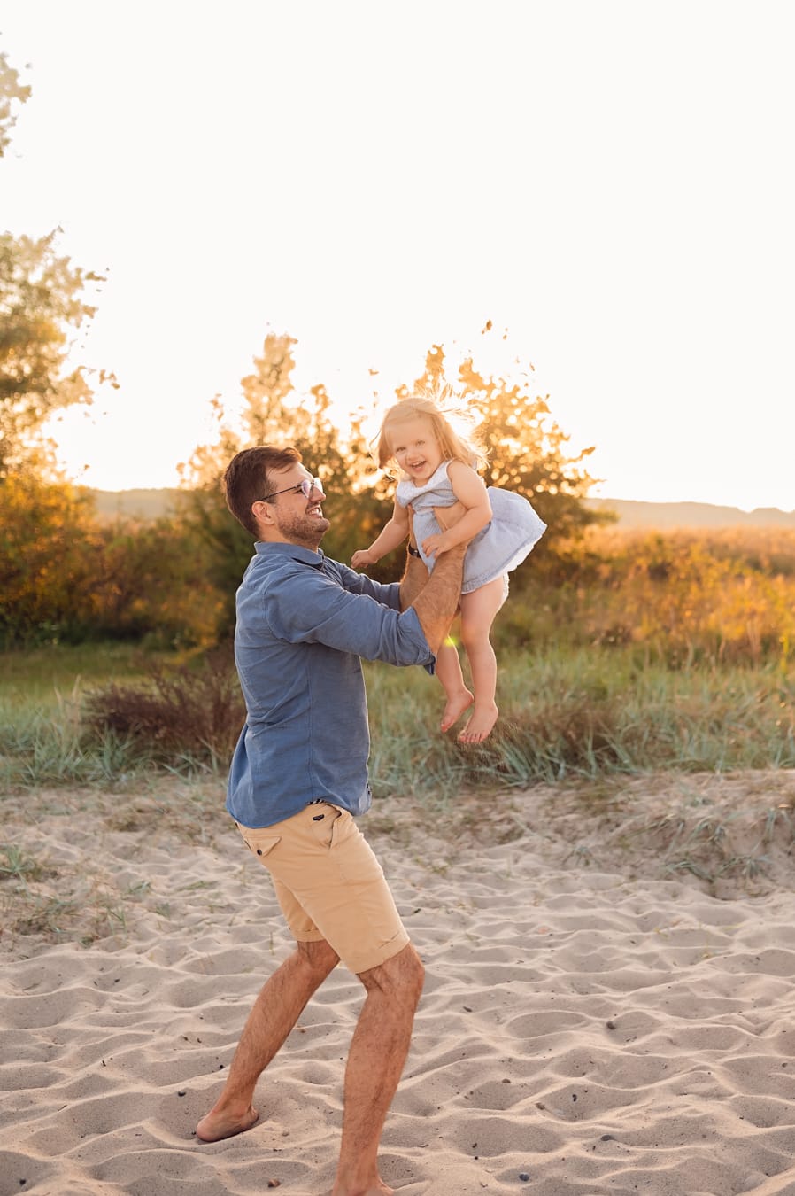 Tata bawi się z córką zachód słońca sesja nad morzem