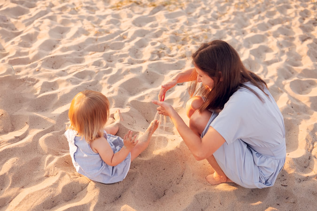 Mama z córką bawią się w piasku sesja nad morzem