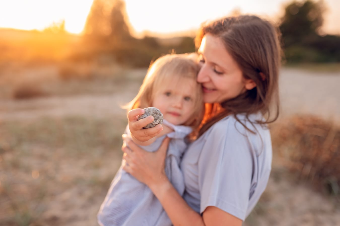 Córka pokazuje mamie kamyk zachód słońca sesja