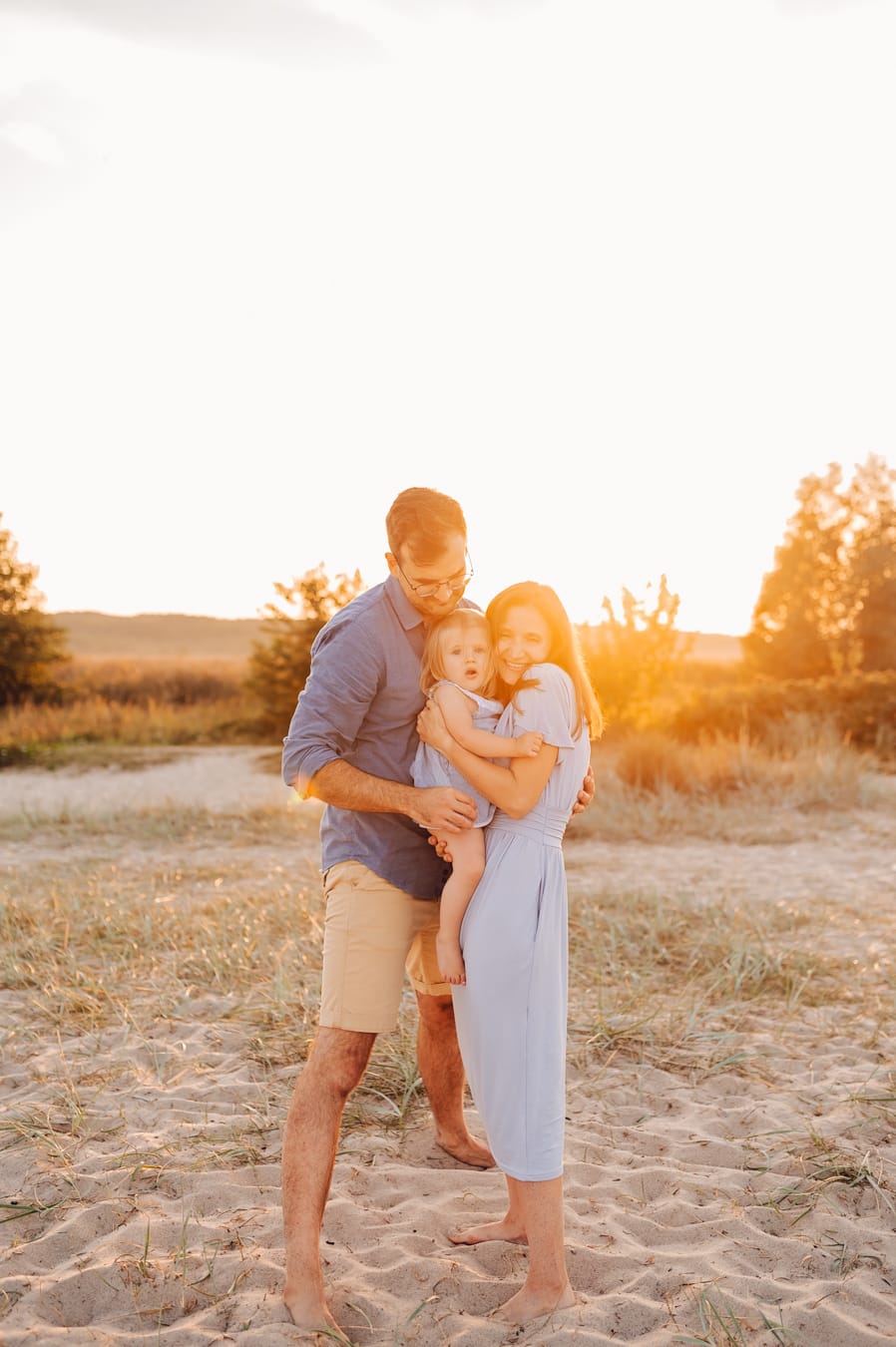 Rodzice z córką zachód słońca sesja nad morzem
