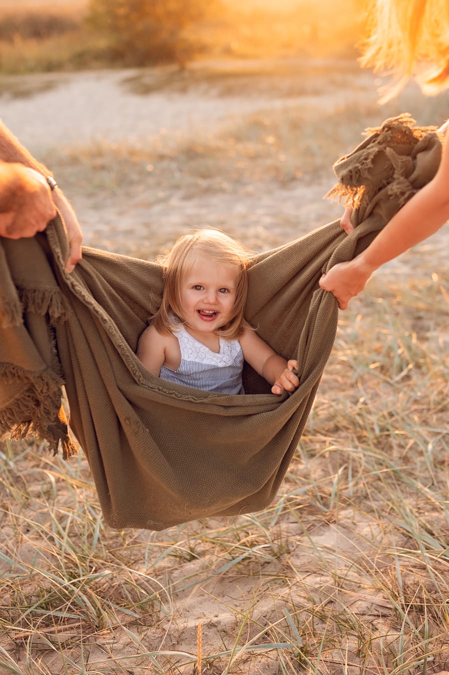 Córka huśtana w kocu zachód słońca sesja nad morzem