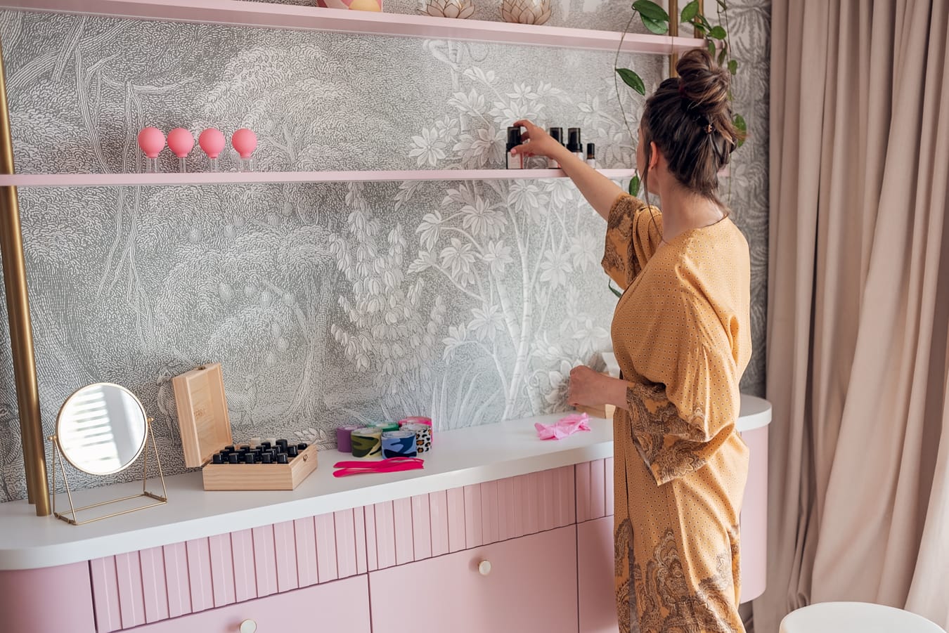 Terapeutka w kimono przygotowuje mieszankę, otaczając się naturalnymi składnikami.