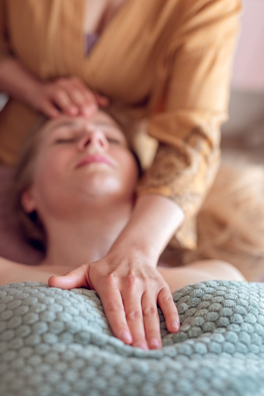 Terapeutka wykonuje delikatny masaż twarzy klientki, relaksując mięśnie i poprawiając owal twarzy.