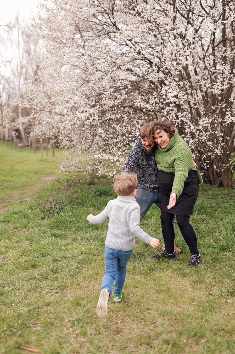 Tata przytula ciężarną mamę syn biegnie sesja ciążowa w plenerze