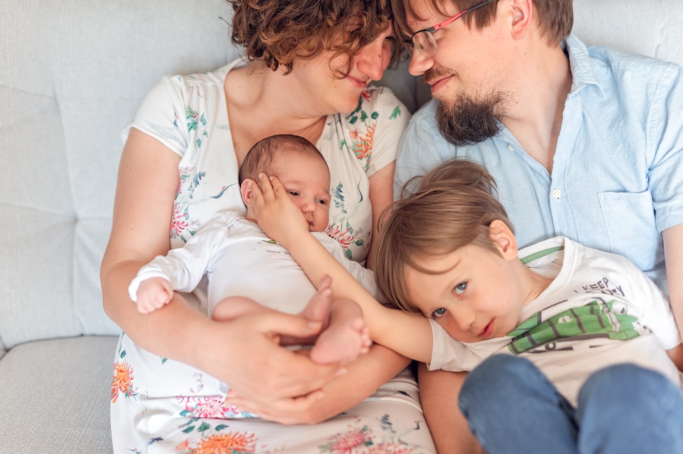 Rodzina tuląca się na kanapie sesja noworodkowa lifestyle