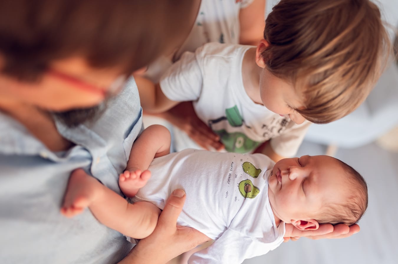 Starszy brat patrzy na noworodka rodzeństwo sesja w domu