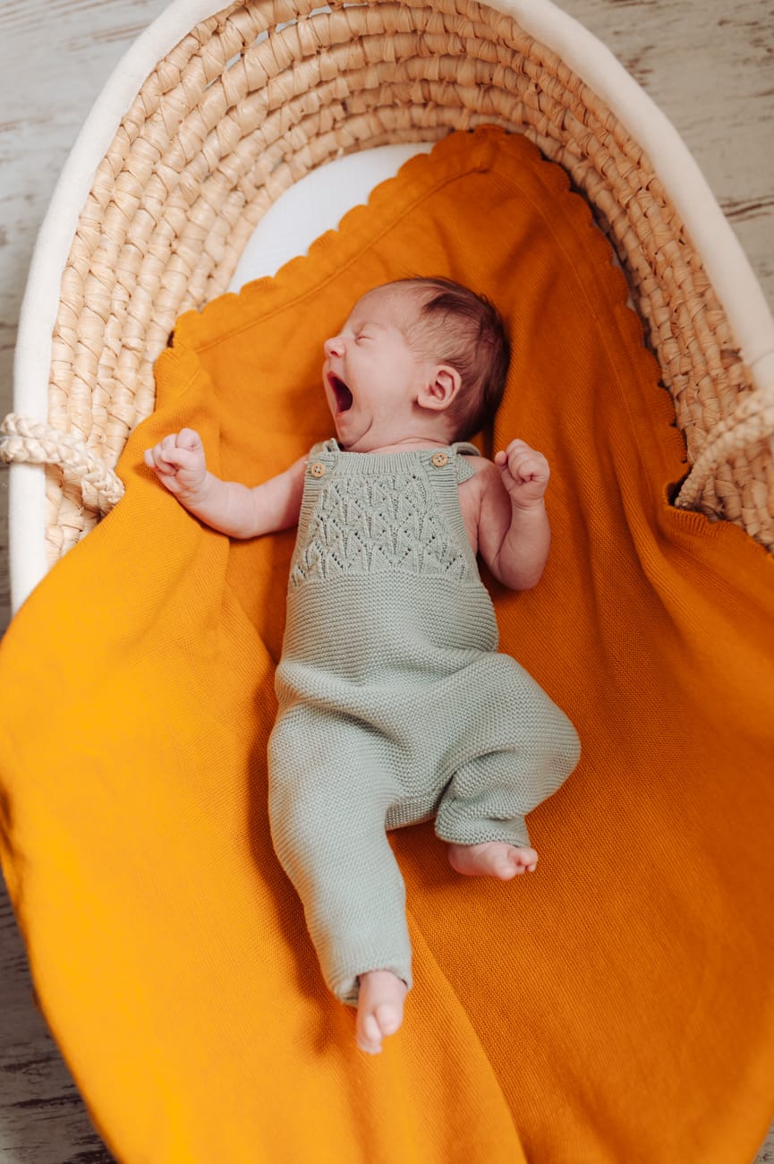 Noworodek ziewa w koszyku sesja noworodkowa mama z dziećmi