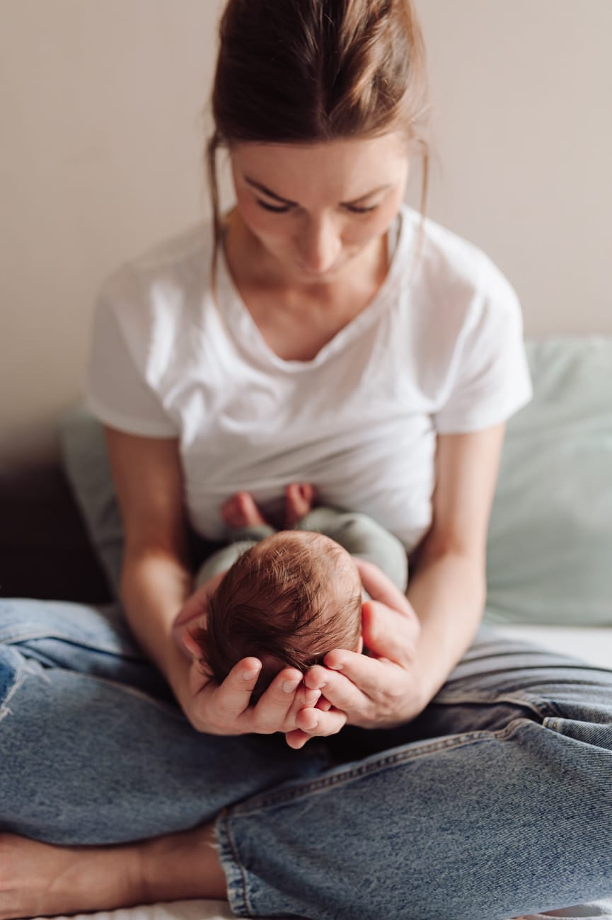 Mama patrzy na noworodka sesja mama z dziećmi