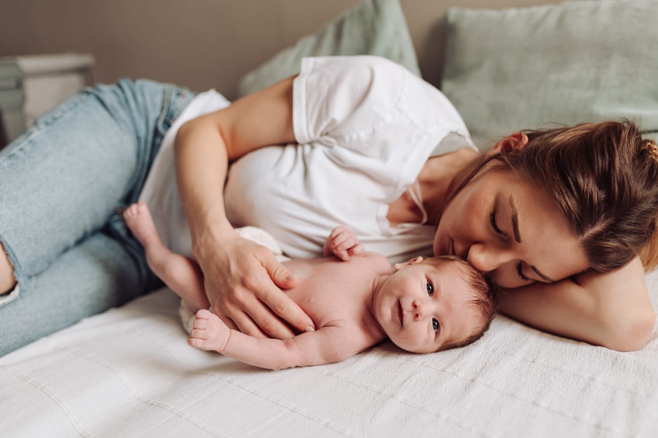 Mama i noworodek w sypialni sesja noworodkowa w domu