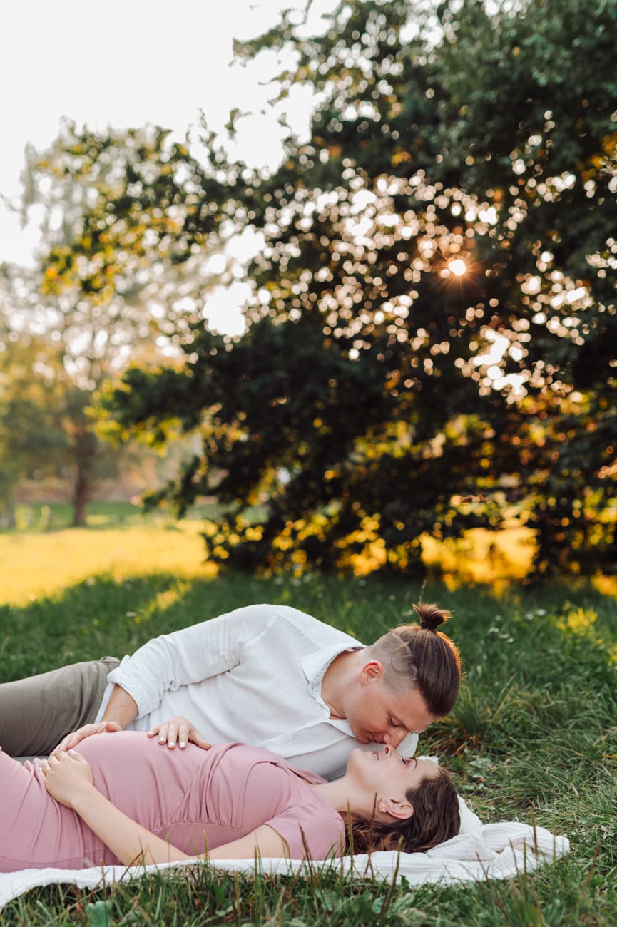 Para leży na łące zachód słońca sesja ciążowa Gdynia