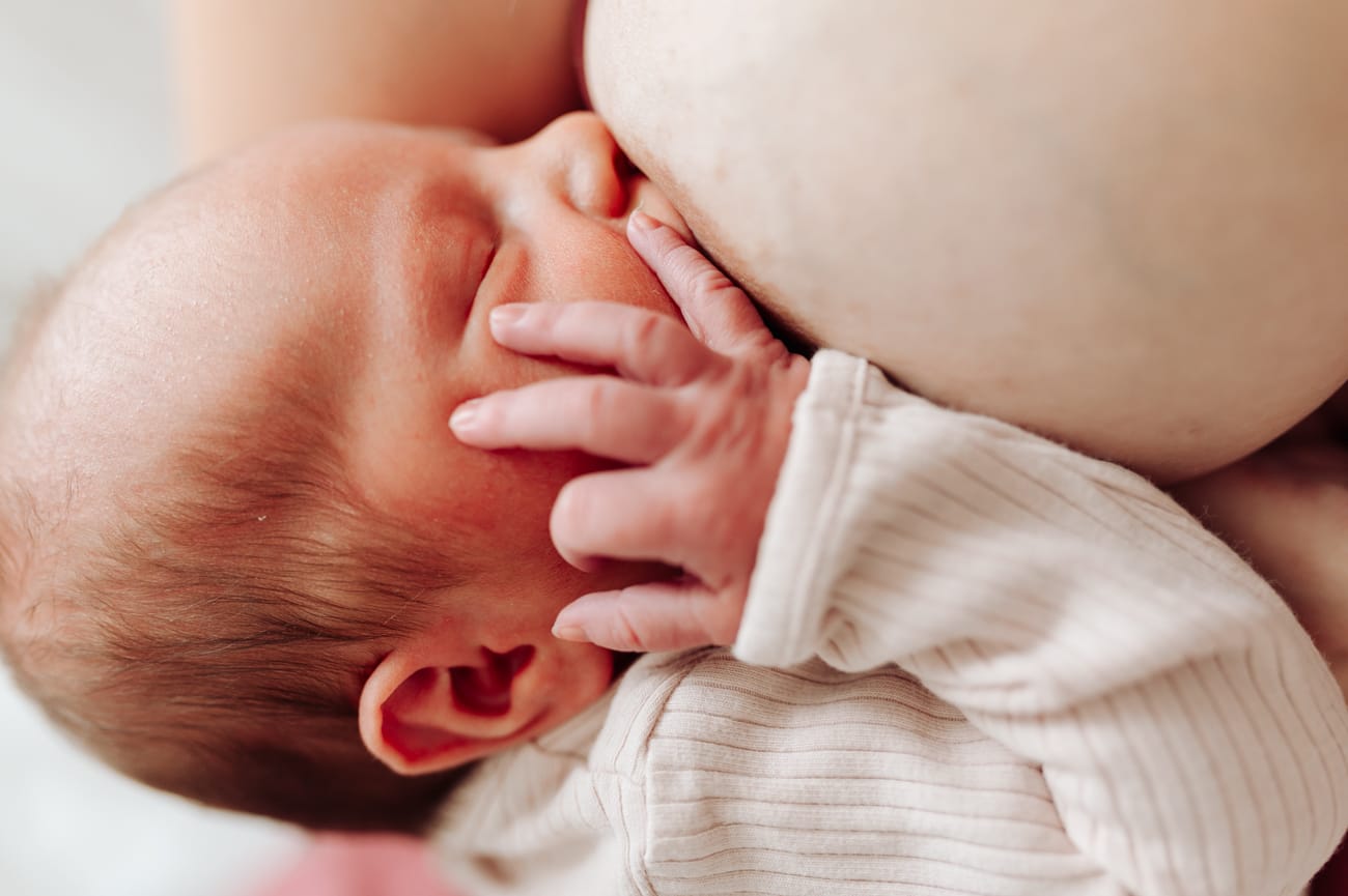 Rączka noworodka przy piersi mamy sesja w szpitalu Gdańsk