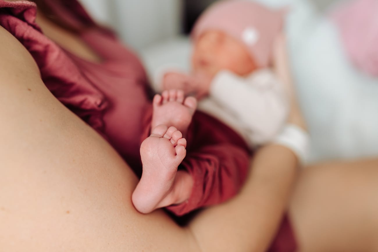 Stópki noworodka w ramionach mamy sesja w szpitalu Gdańsk