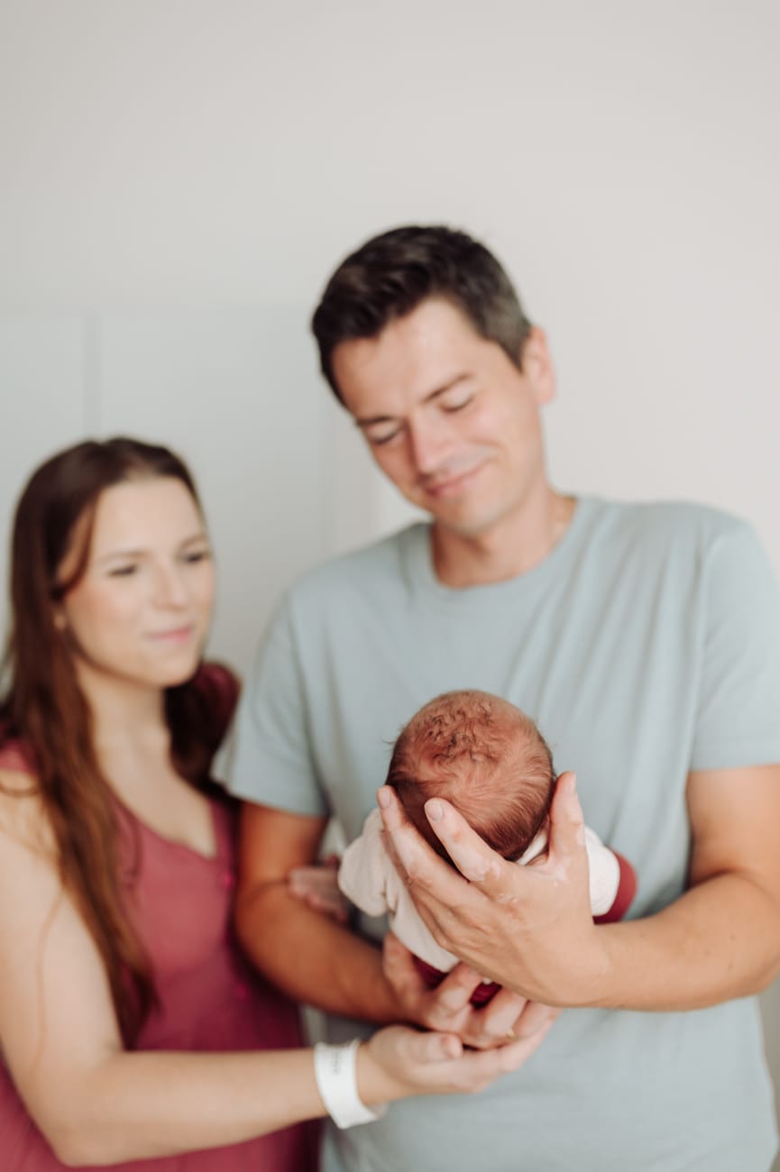 Rodzice patrzą na noworodka sesja w szpitalu Gdańsk