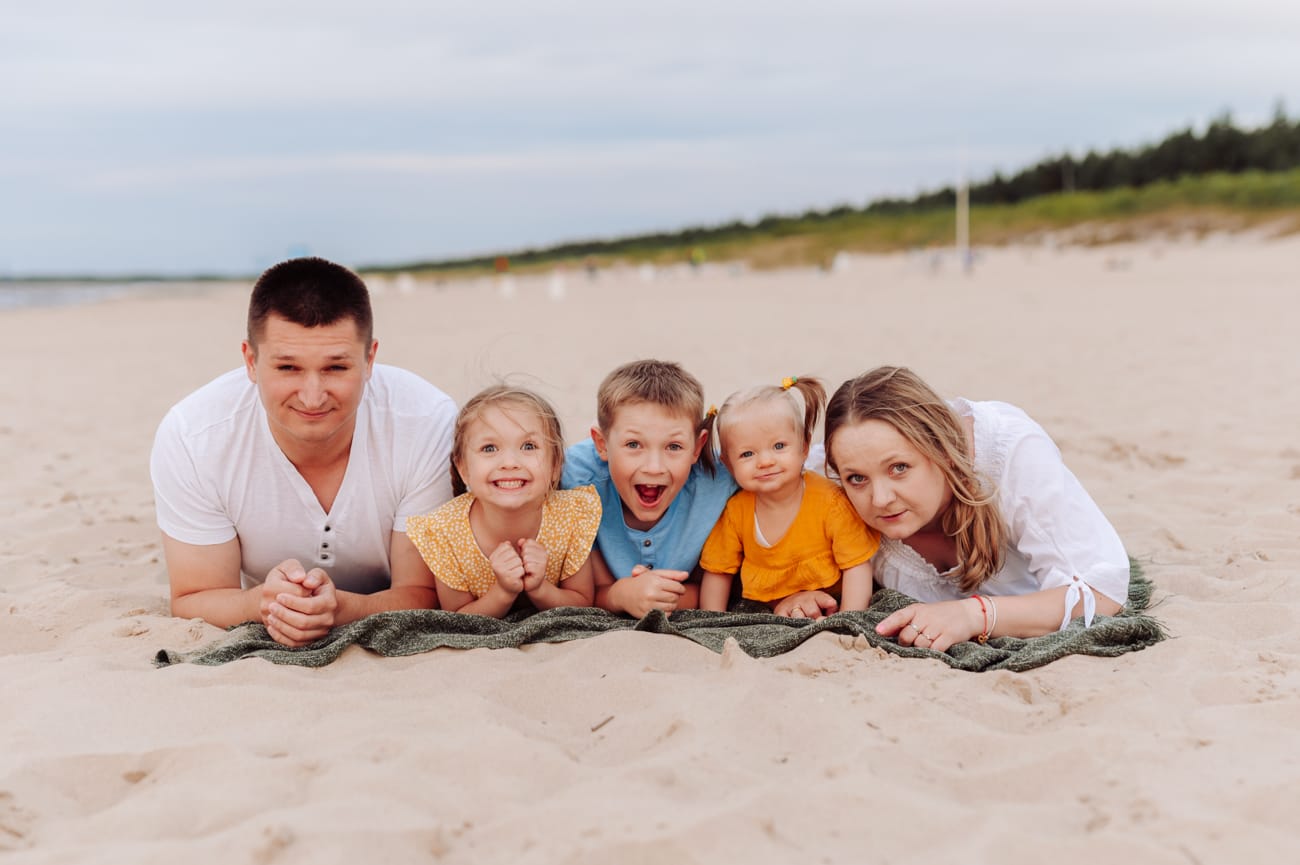 Rodzina leży na kocu na plaży portret sesja wakacyjna