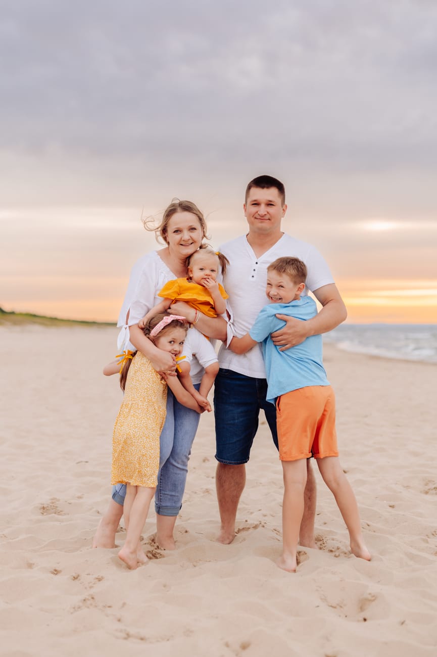 Rodzina przytulona pochmurny wieczór sesja nad morzem