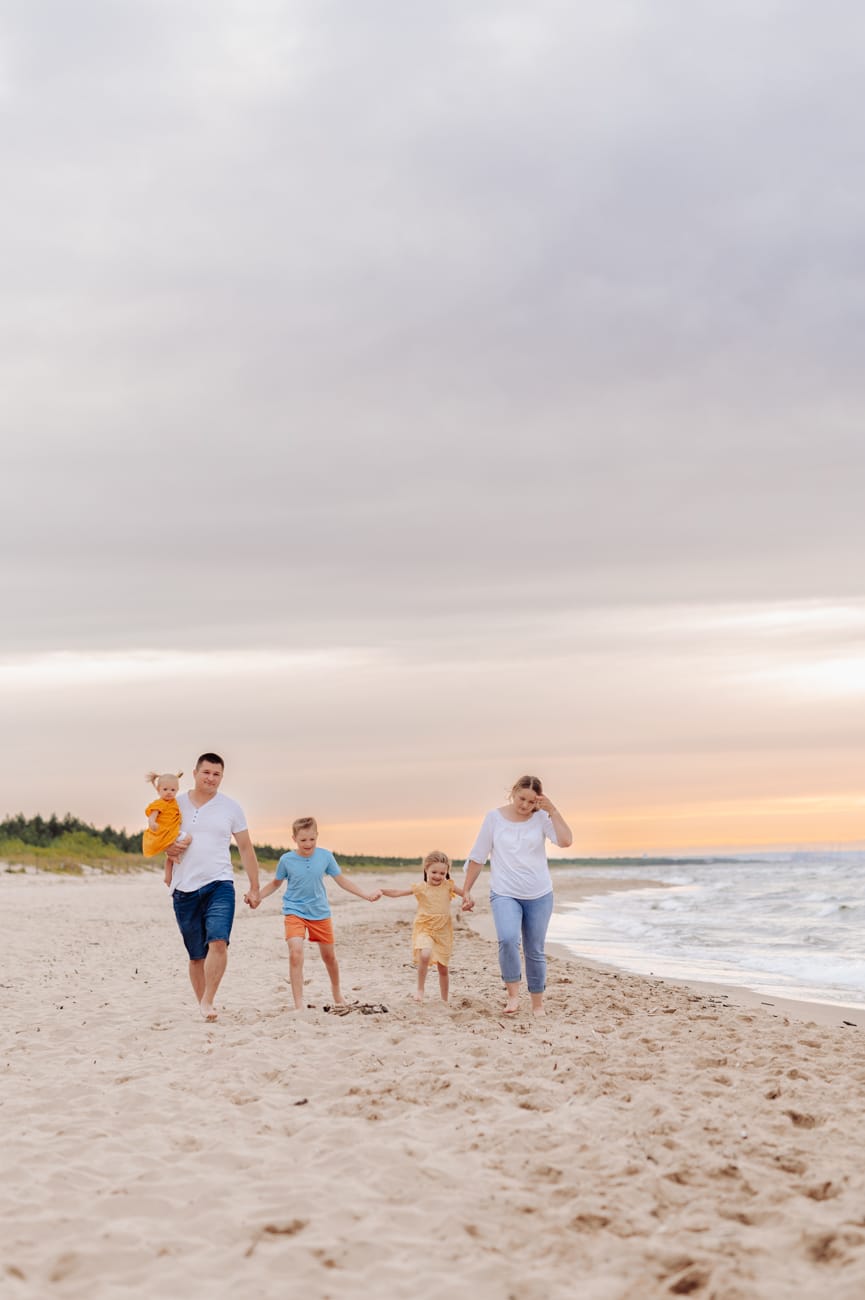 Rodzina spaceruje brzegiem morza zachód słońca Gdańsk