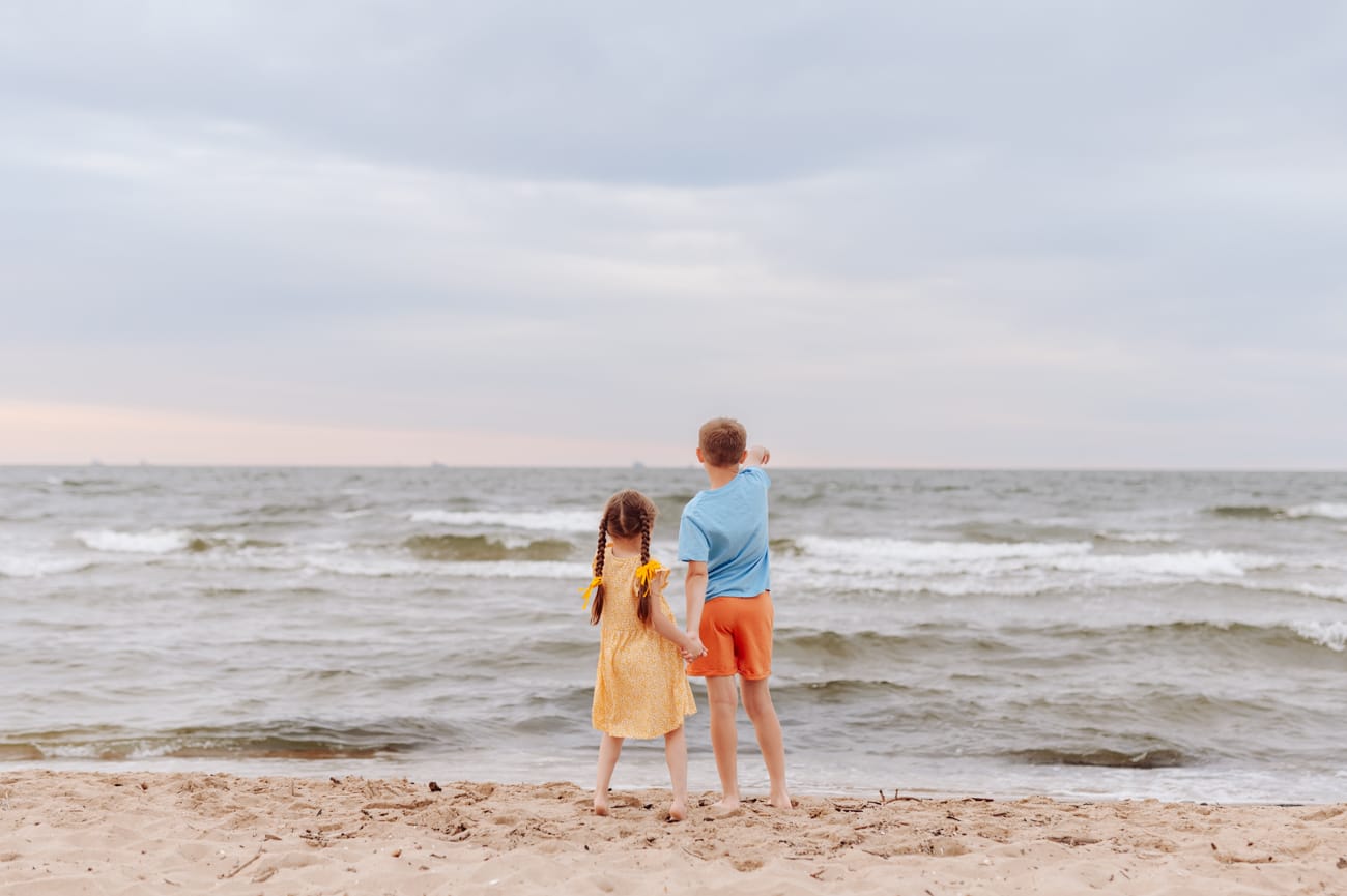 Dzieci pokazują łódki na morzu sesja rodzinna w wakacje