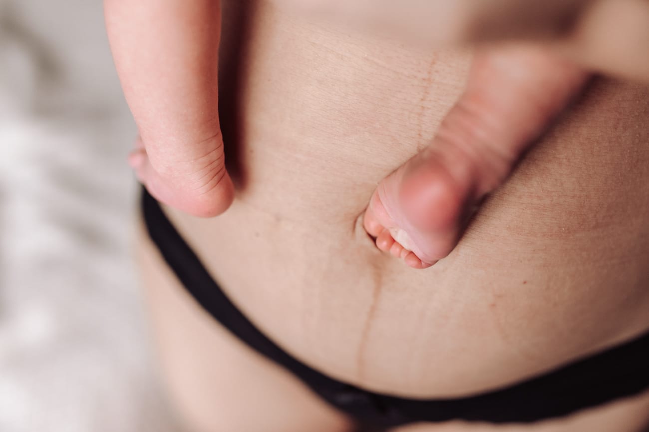 Brzuch poporodowy mamy i stópki noworodka sesja Gdynia