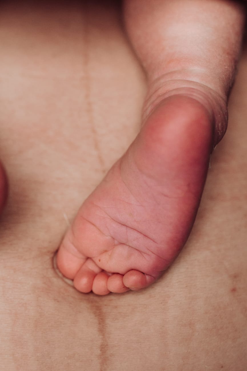 Stopa noworodka i brzuch mamy detal sesja Gdynia