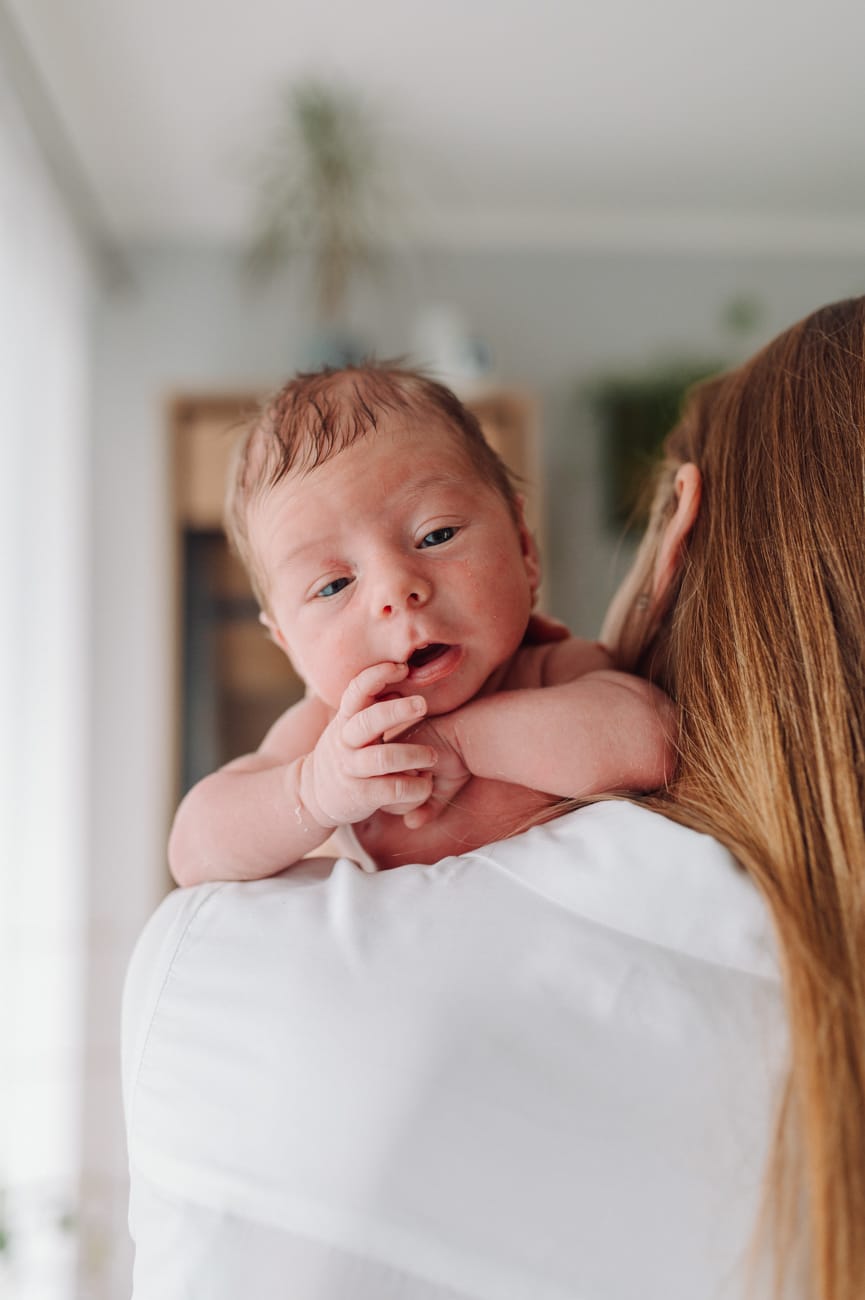 Noworodek leżący na ramieniu mamy - domowa sesja noworodkowa  lifestyle Trójmiasto.