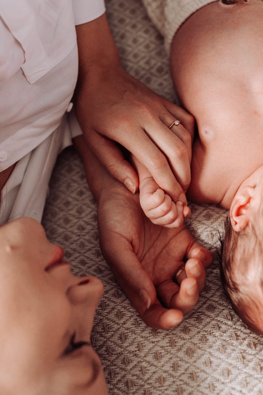 Dłoń mamy i noworodka detal sesja w domu Gdynia