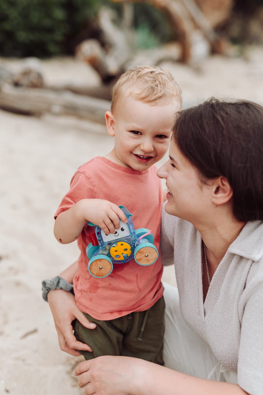 Dwulatek bawi się z mamą autkiem na plaży sesja rodzinna Gdynia