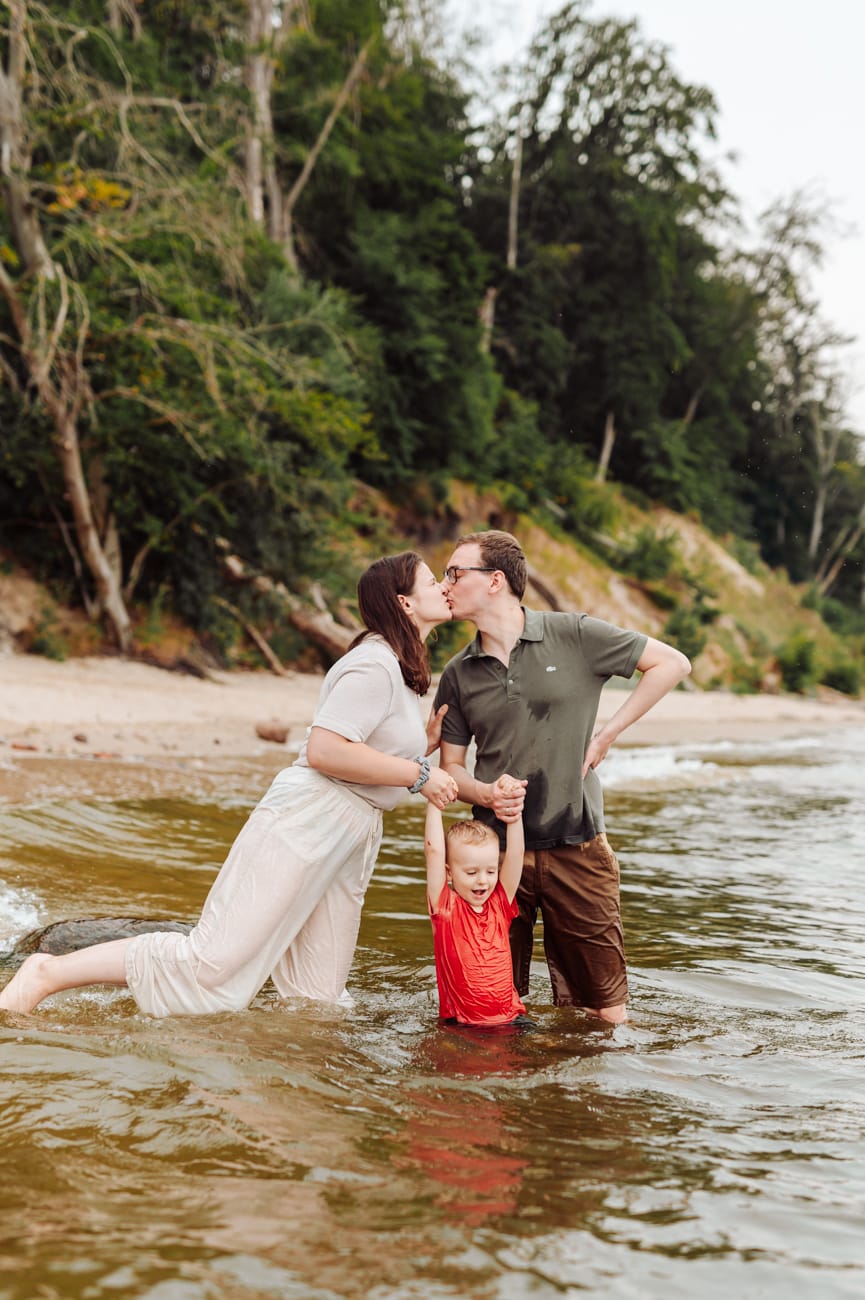 Rodzice całują się dwulatek między nimi morze Gdynia