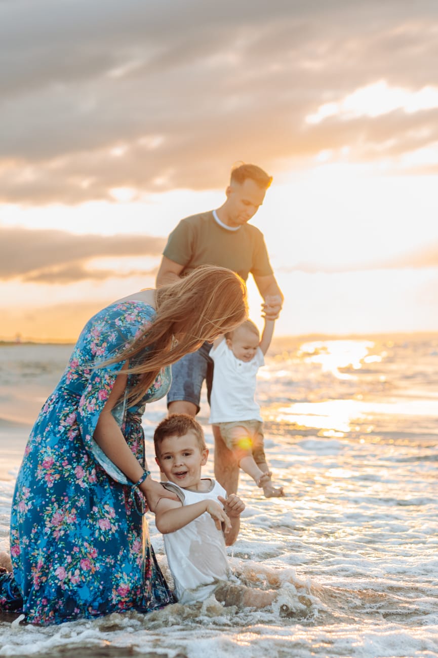 Chłopcy skaczą przez fale zachód słońca