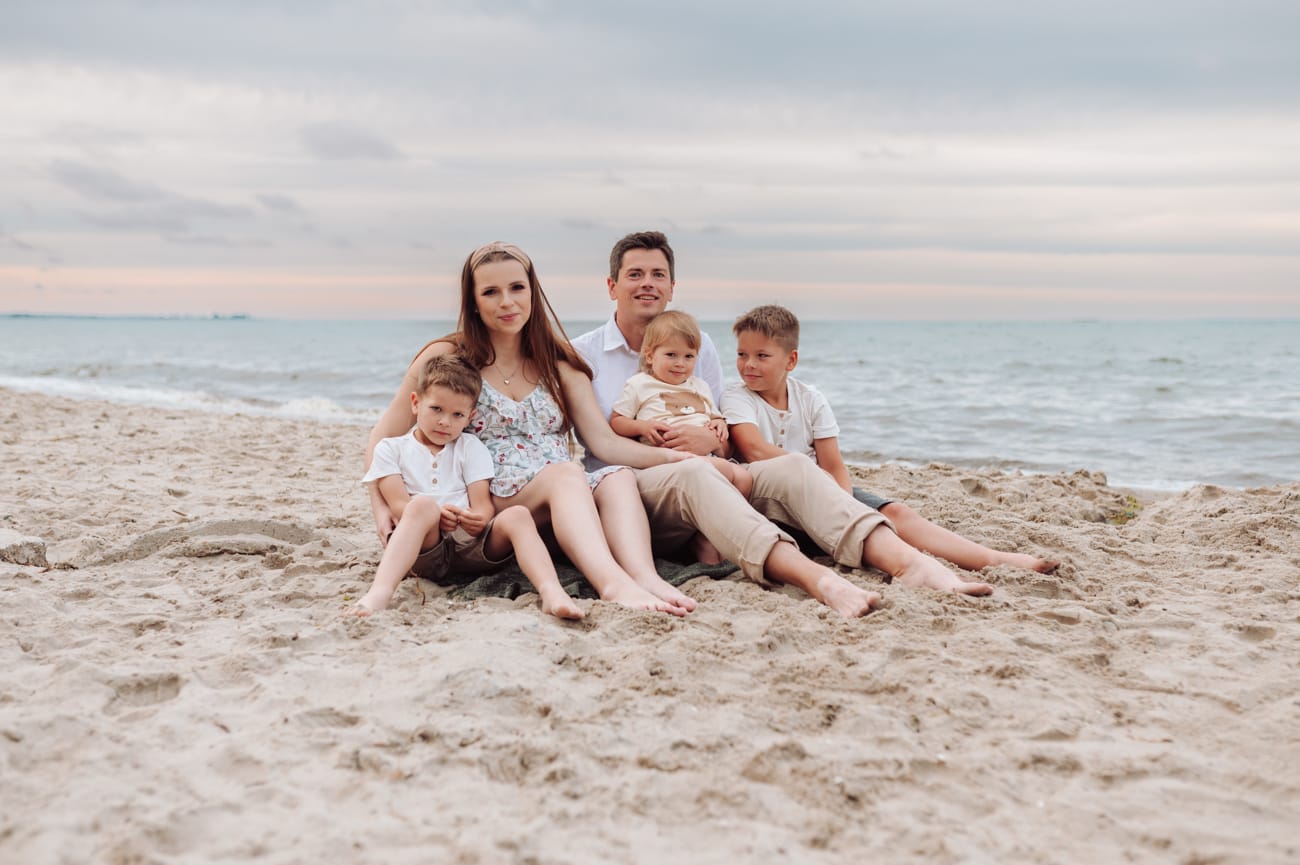 Rodzina na brzegu morza pastelowy zachód słońca Gdynia