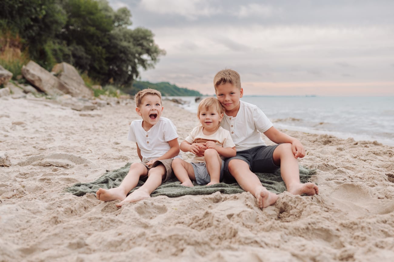 Chłopcy bawią się na plaży sesja ciążowa Gdynia