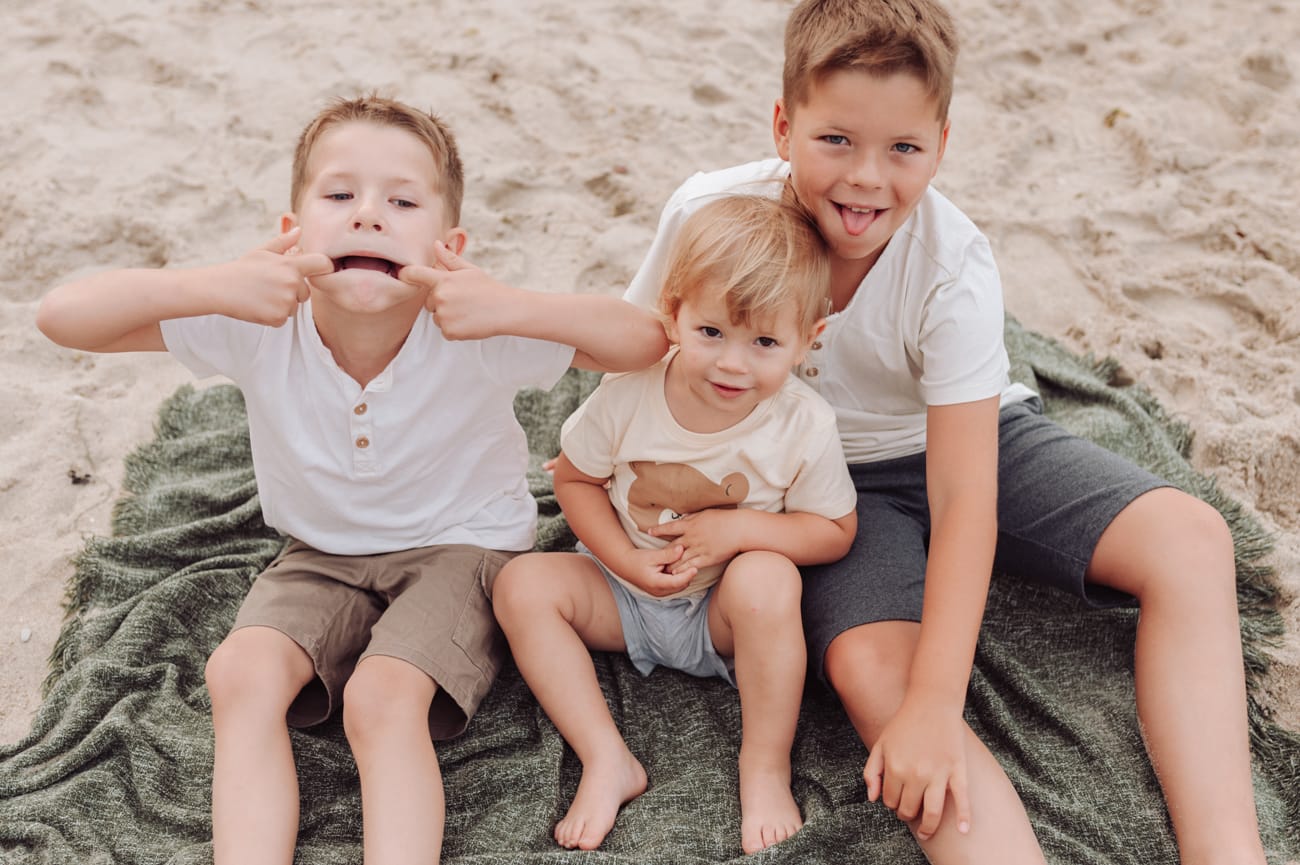 Chłopcy bawią się na plaży sesja ciążowa Gdynia