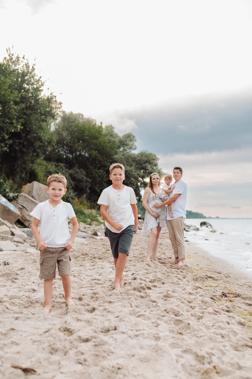 Chłopcy biegną po plaży sesja ciążowa Gdynia