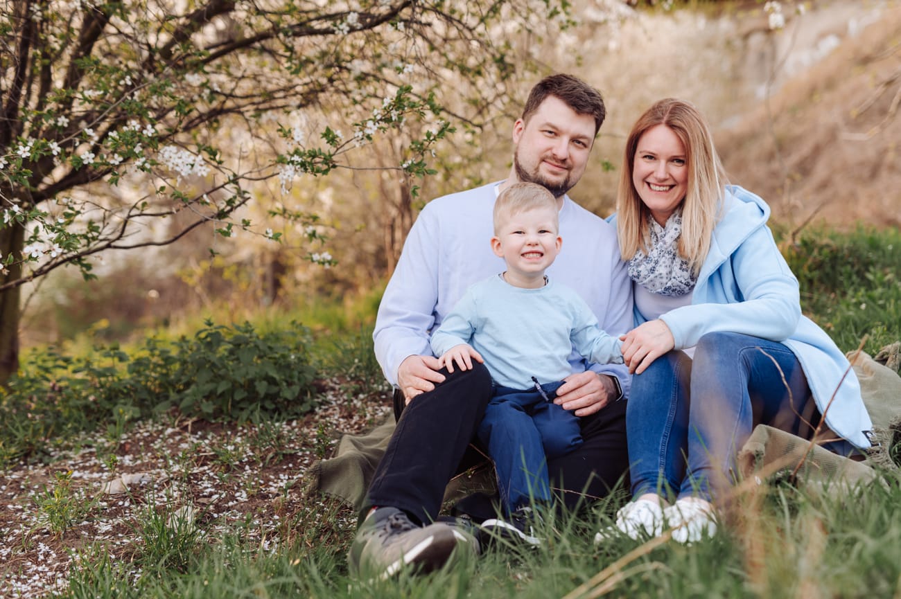 Portret rodzinny pod kwitnącym drzewem sesja wiosenna
