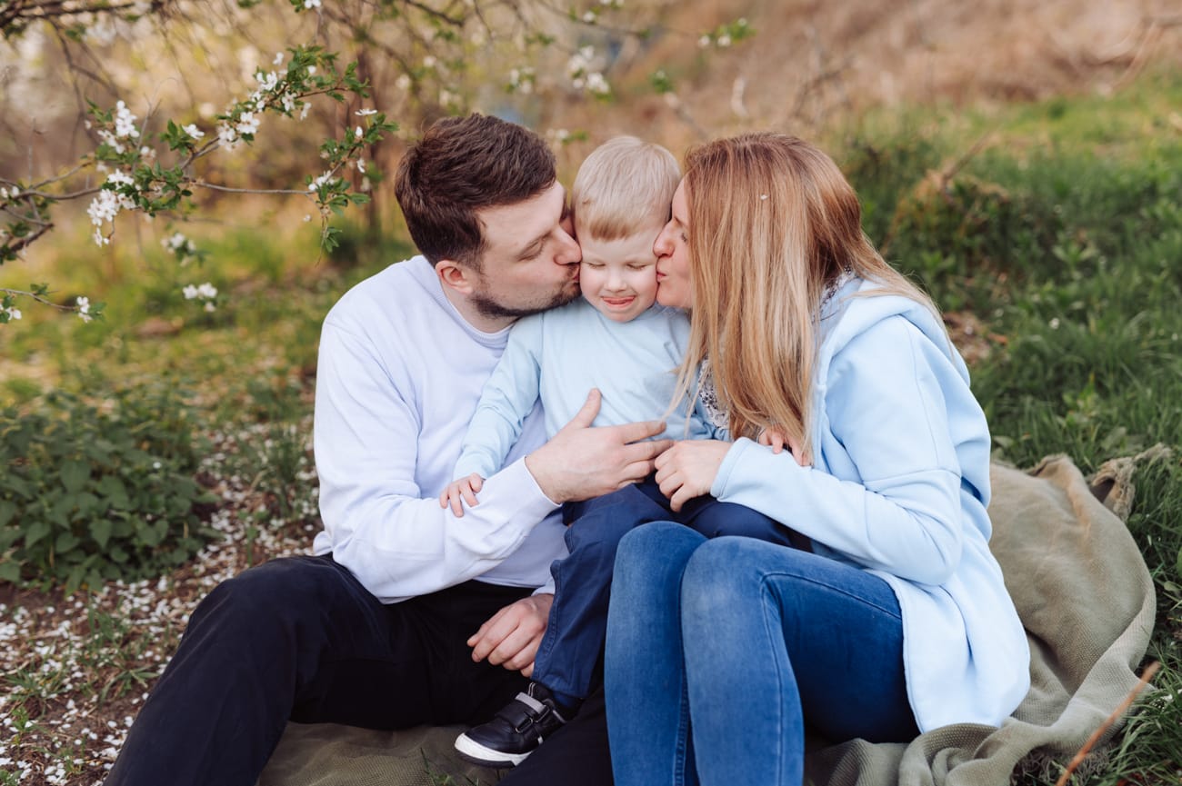 Rodzice całują synka wiosenna sesja rodzinna