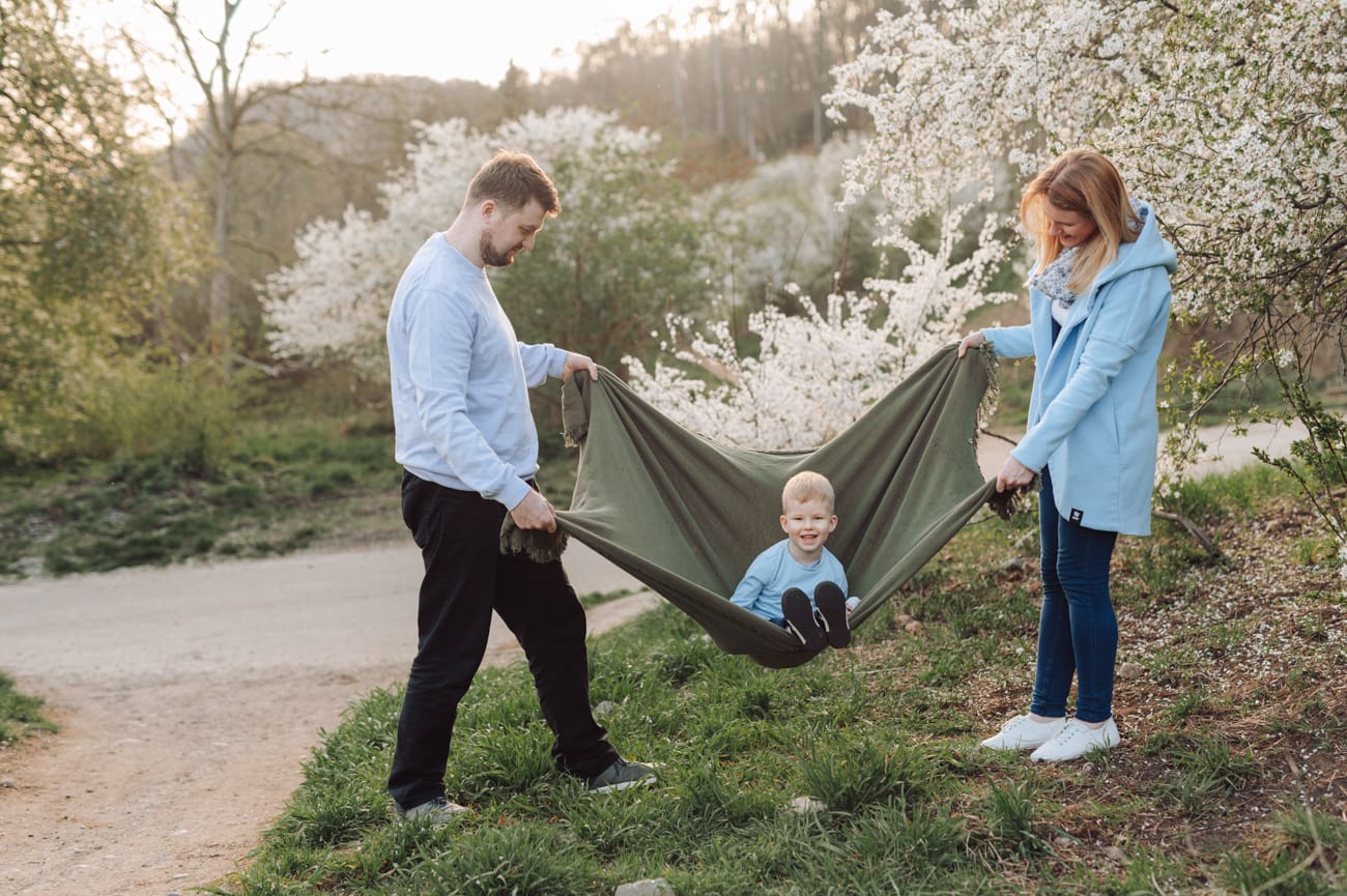 Rodzice bujają syna w kocu wiosenna sesja rodzinna