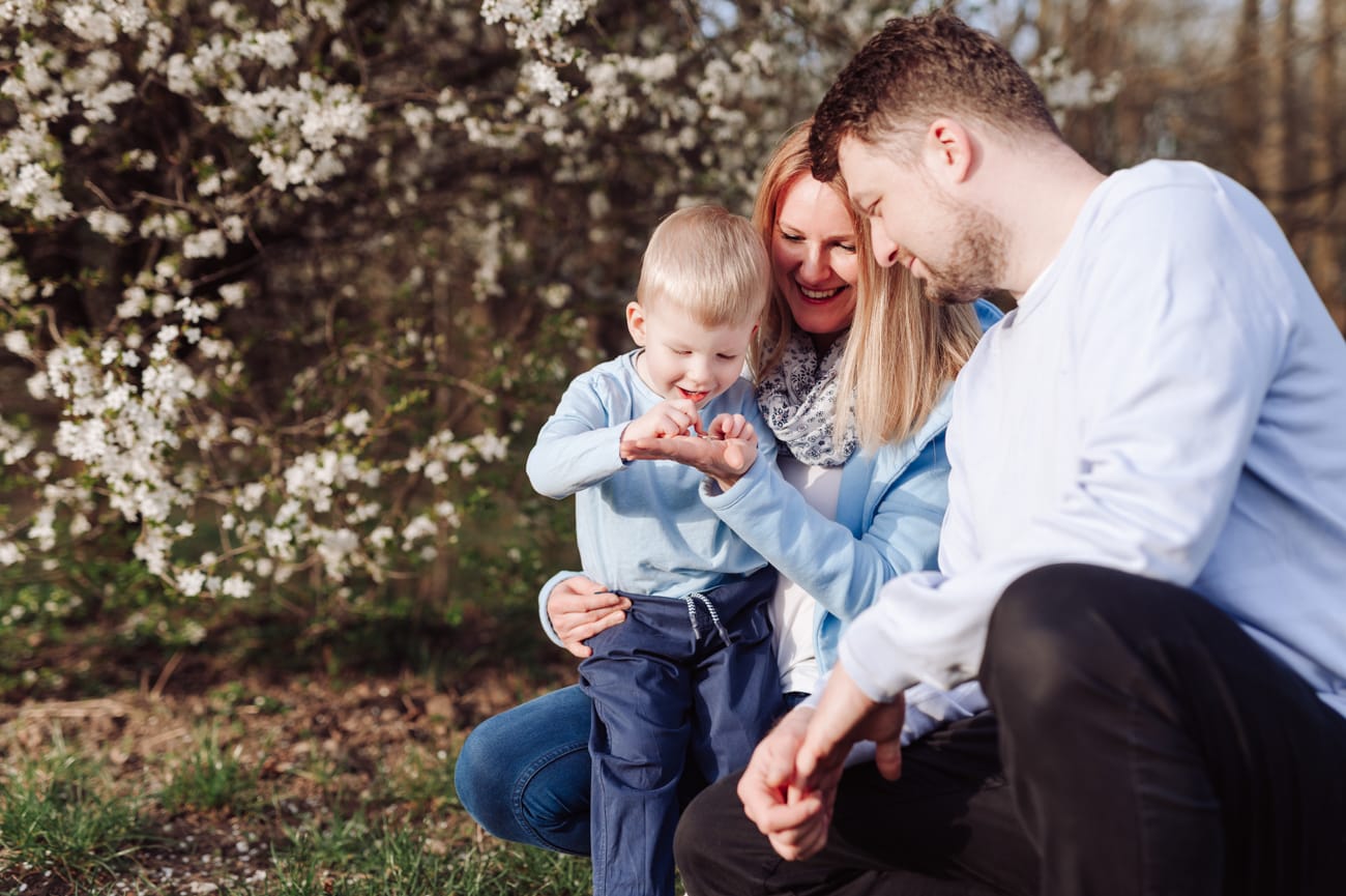 Rodzina bawi się wśród kwitnących drzew sesja wiosenna
