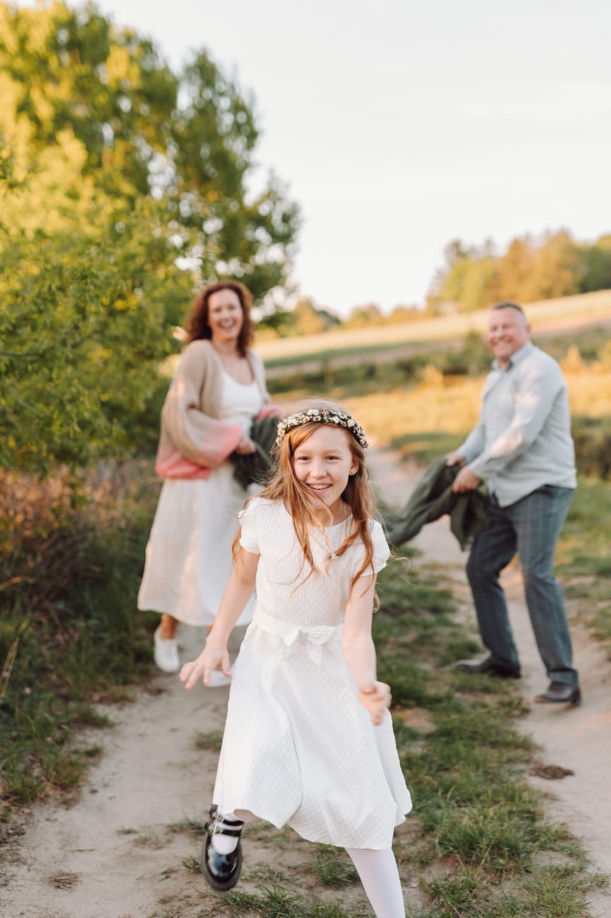 Dziewczynka biegnie i śmieje się plener komunijny
