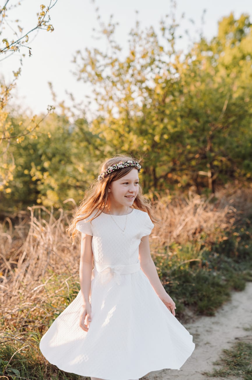 Dziewczynka tańczy na łące plener komunijny