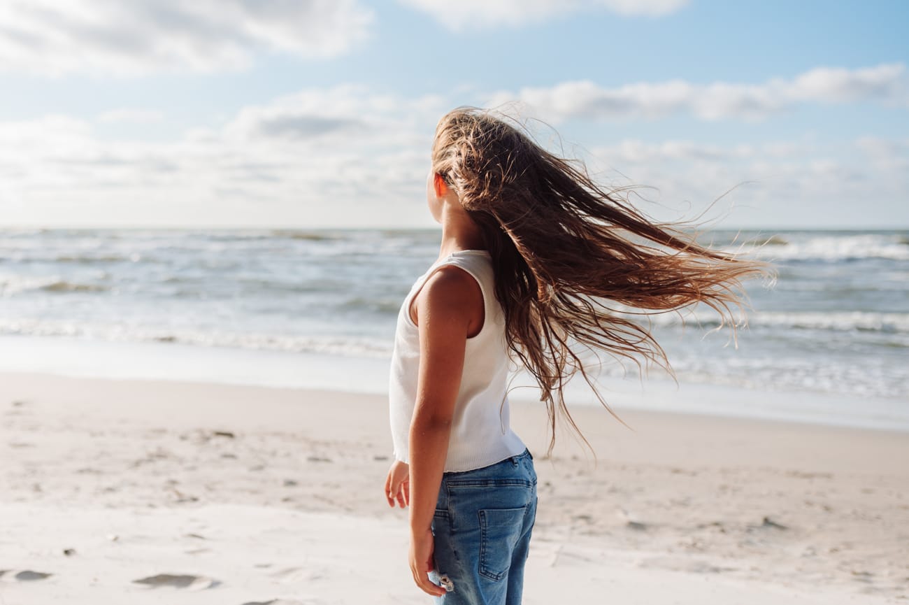 Rozwiane włosy na wietrze sesja rodzinna na plaży