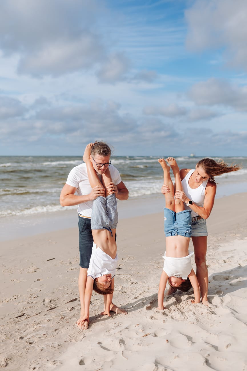 Rodzice trzymają dzieci, które stoją na rękach nadmorska sesja rodzinna